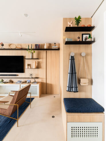 Hall de entrada pequeno com móveis em MDF claro e decoração azul-marinho
