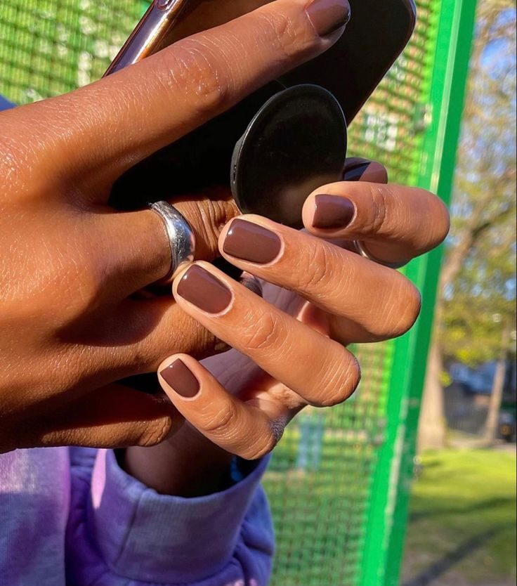 Mãos de pele preta, com anéis em prata e unha Mocha Mousse