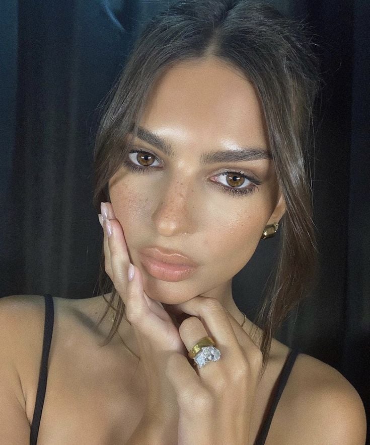Mulher de pele clara-médica, com regata preta, cabelo escuro preto e maquiagem Mocha Mousse