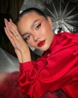 Mulher de pele preta, com roupa e lábio vermelho