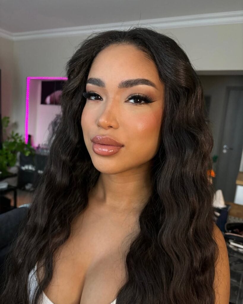 Mulher de pele preta, com cabelo escuro e maquiagem com delineado fininho