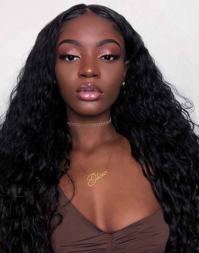 Mulher de pele preta, com cabelo cacheado e maquiagem rose gold 