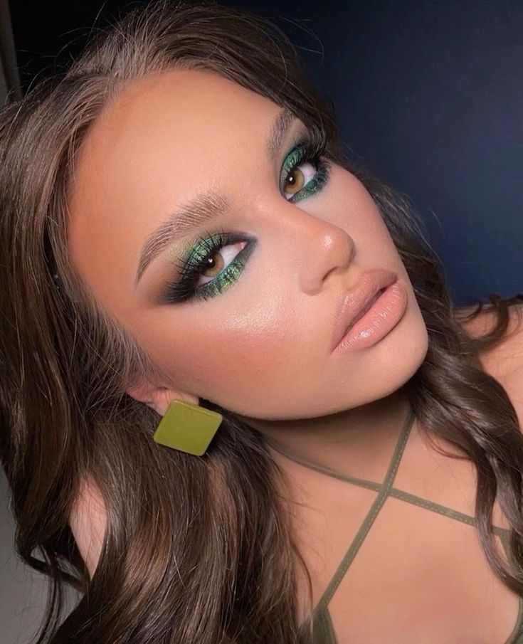Mulher de pele clara, com cabelo castanho e maquiagem verde-esmeralda 