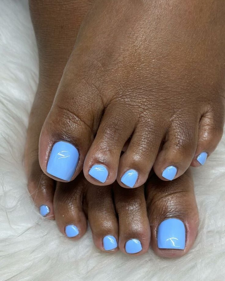 Pés de pele preta, com unha azul-claro