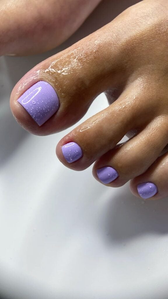 Pés de pele clara com unha lavanda