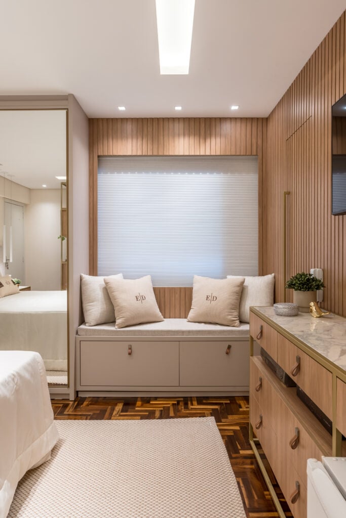 Quarto com estilo sofisticado, cama de casal, mesas de cabeceira e guarda-roupa com espelho, ripado na parede e gesso com sanca iluminada