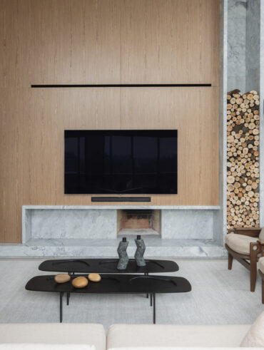 Sala de estar com lareira e painel de madeira