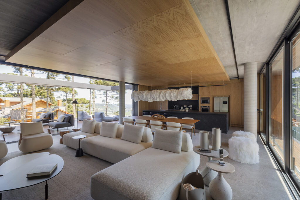Sala de estar com sofá branco e grande e poltronas