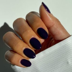 Mão de pele média, com unha amendoada e curta azul-marinho