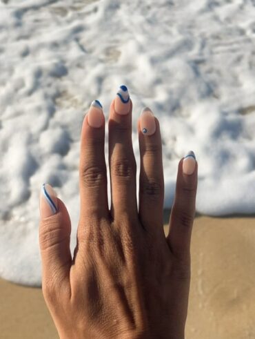 Mão de pele preta, com unha amendoada com linhas fluidas em azul