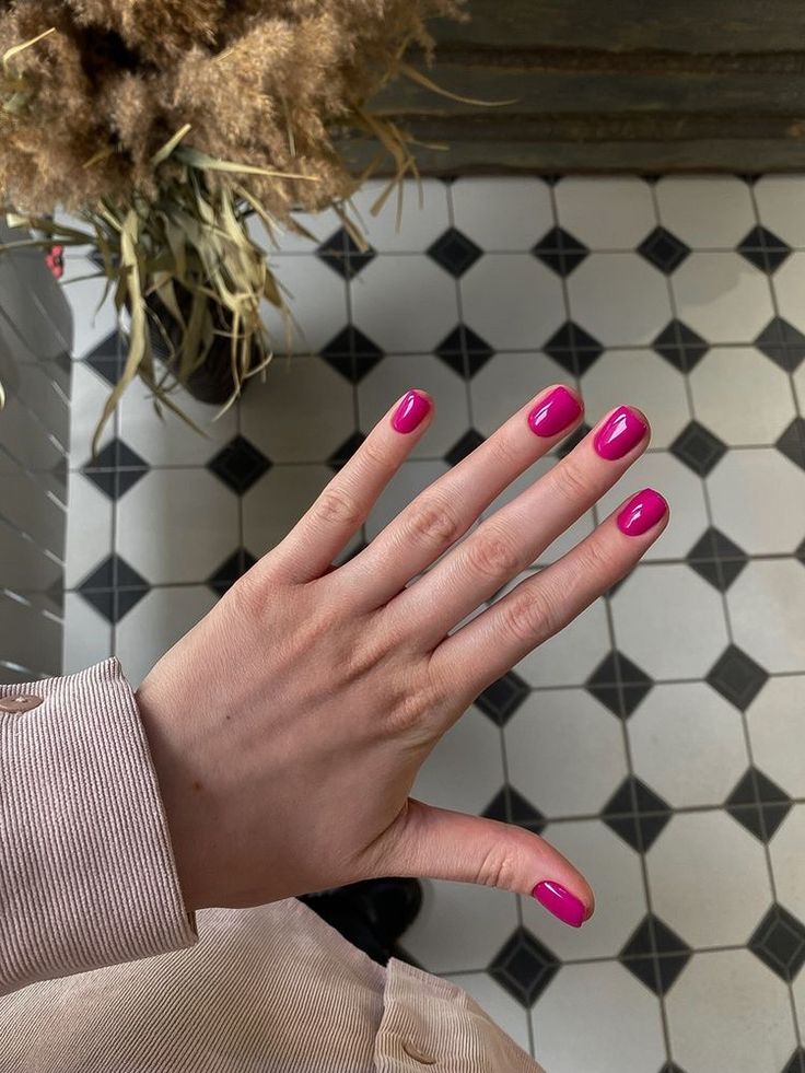 Mão de pele clara, com unha curta e quadrada rosa