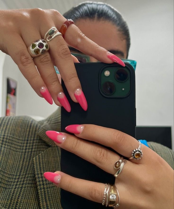 Mão de pele branca, com unha longa e redonda usando esmalte rosa, com nail art cut out