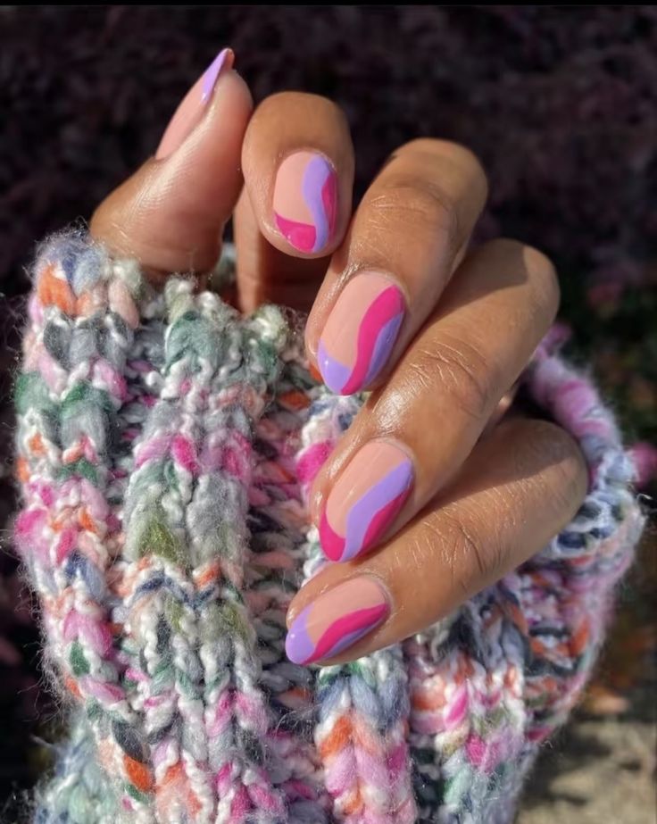 Mão de pele preta, com unha amendoada lilás e rosa 