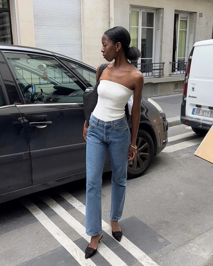 Mulher jovem com blusa sem alça e calça jeans