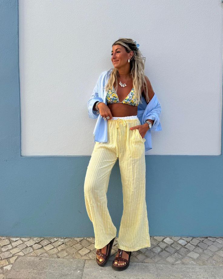 Mulher jovem, magra e de pele clara. Ela usa look de praia.