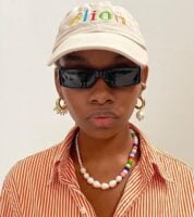 Mulher jovem e negra com colar de miçangas
