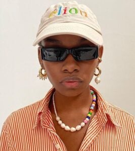 Mulher jovem e negra com colar de miçangas