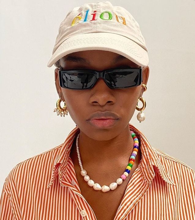 Mulher jovem e negra com colar de miçangas