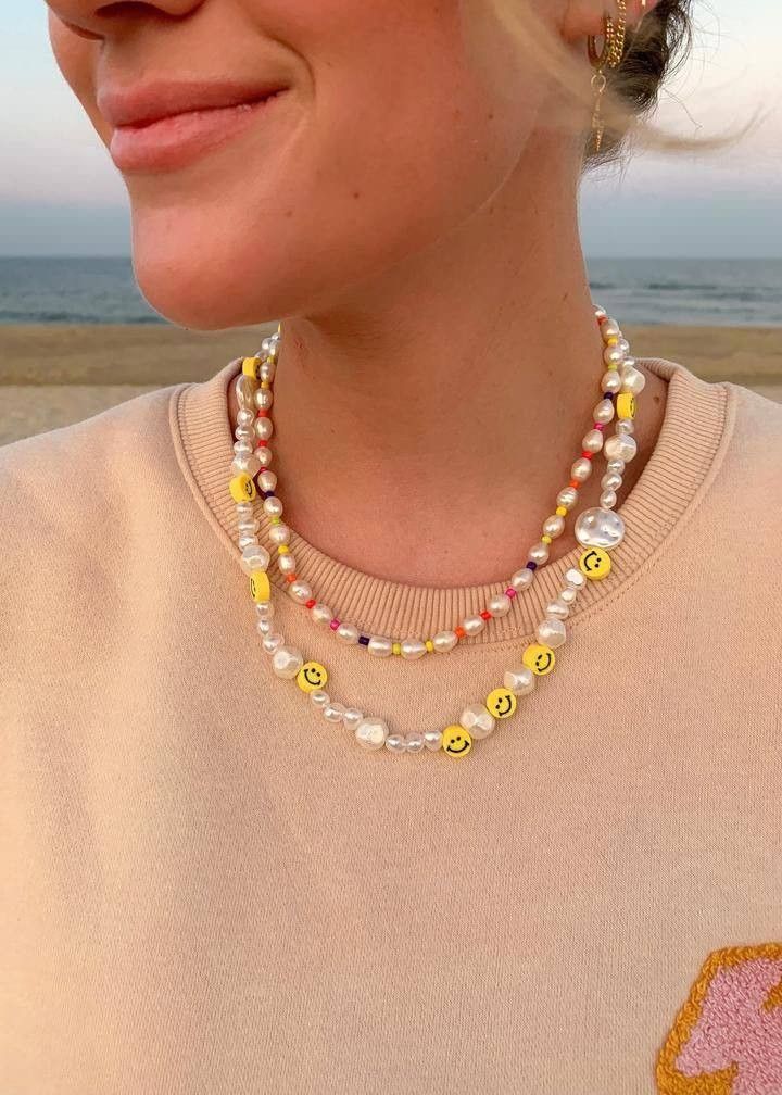 Mulher jovem e branca com colar de miçangas