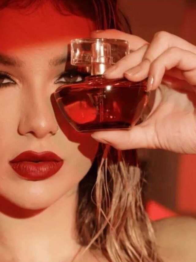 Virgínia Fonseca, com cabelo solto e batom vermelho, segurando o perfume VF Tradicional