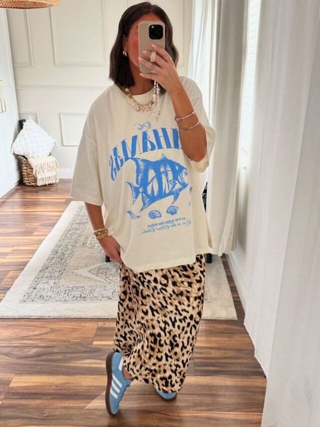 Mulher de pele clara, com blusa estampada em azul, saia de oncinha e Adidas Samba azul