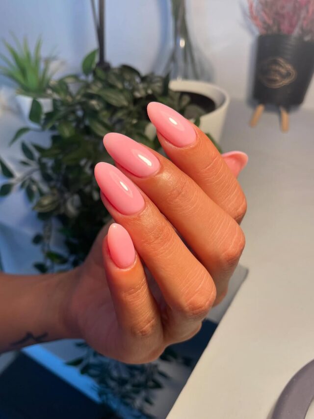 Mão de pele clara, com unha amendoada rosa-claro