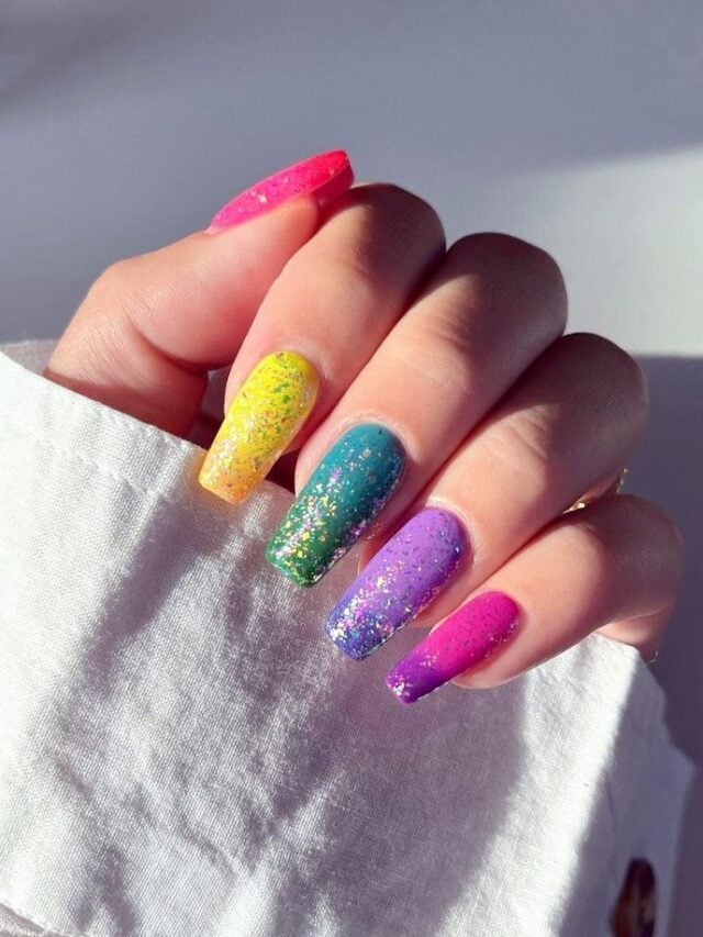 Mão de pele clara, com unha coffin com glitter colorido