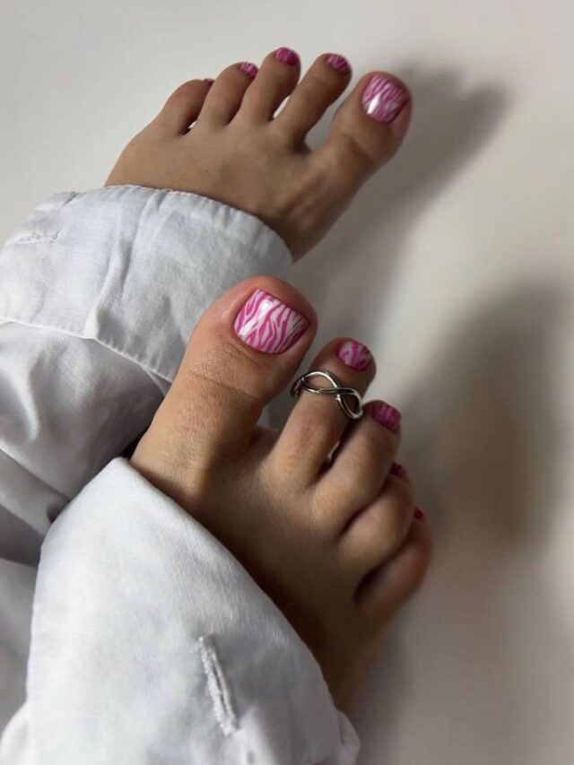 Pés de pele branca, com acessórios em prata e unha do pé rosa decorada