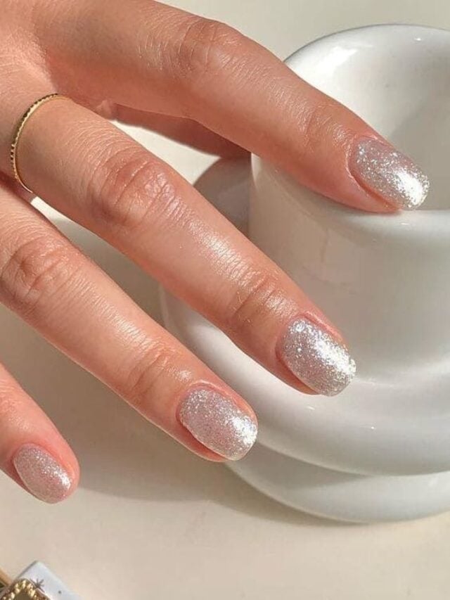 Mão branca com esmalte com glitter
