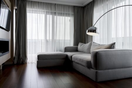Sala de estar com cortina e sofá cinza