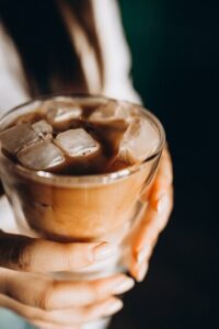 mulher segurando café com leite gelado