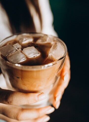 mulher segurando café com leite gelado