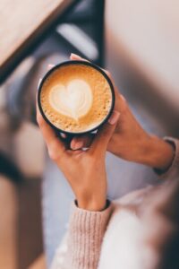 Mão branca segurando xícara de café