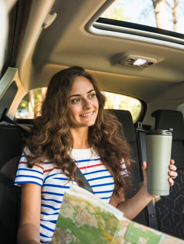 Mulher jovem em viagem de carro.
