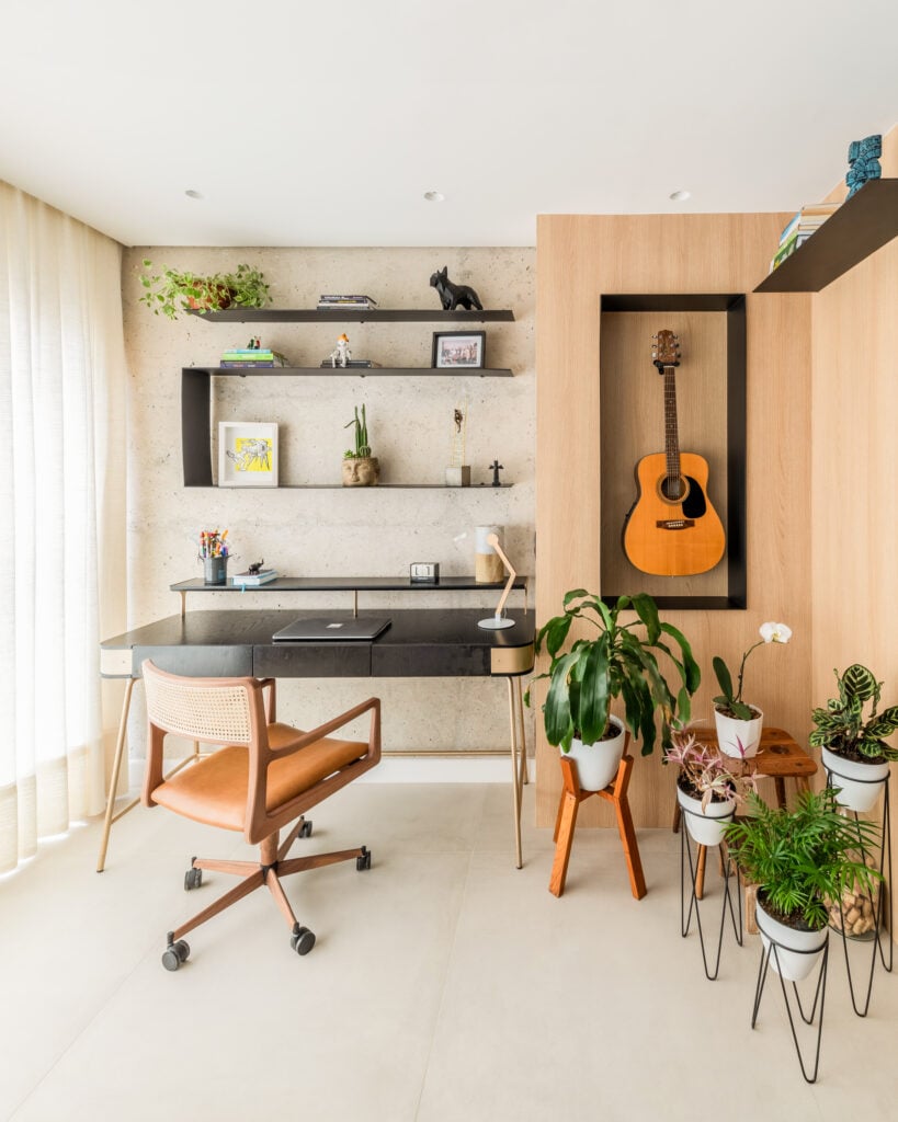 Ambiente com plantas, prateleira e violão na parede