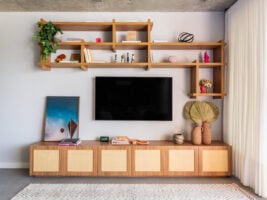 Sala com balcão de madeira com palhinha e prateleira com livros