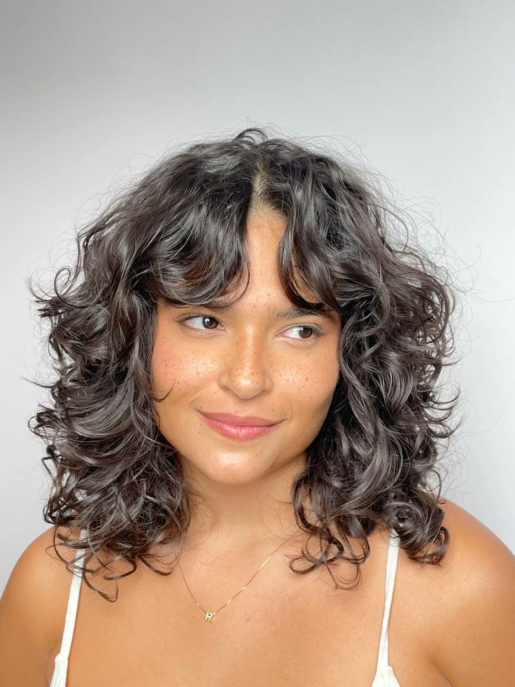 Mulher branca com cabelo preto, curto e em camadas com franja