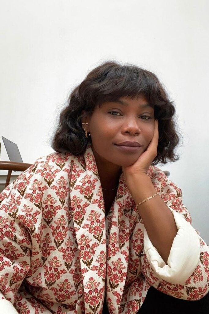 Mulher negra com cabelo preto, curto e reto com franja