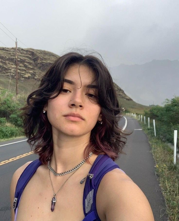Mulher branca com cabelo castanho e ruivo, curto e em camadas com franja