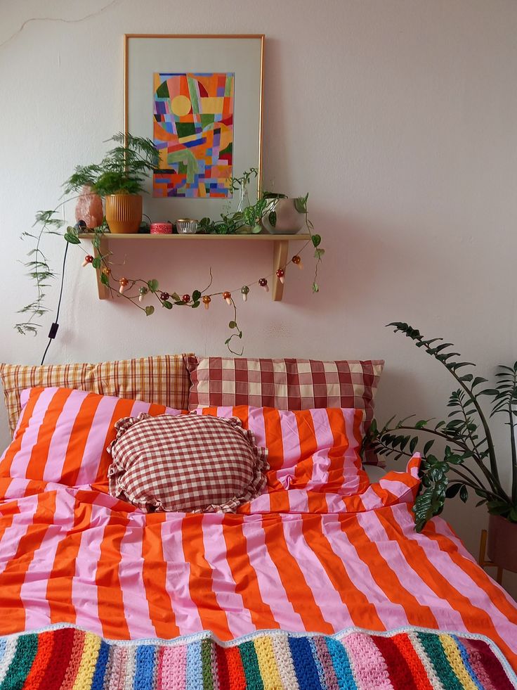 Quarto com cama com prateleira, plantas e quadros