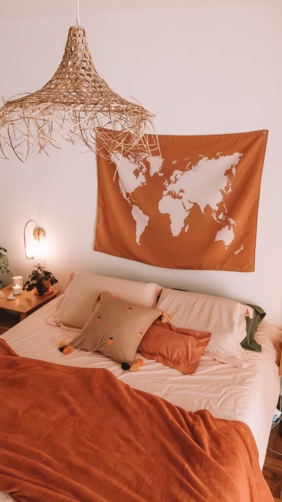 Quarto com cama sem cabeceira e com tapeçaria na parede