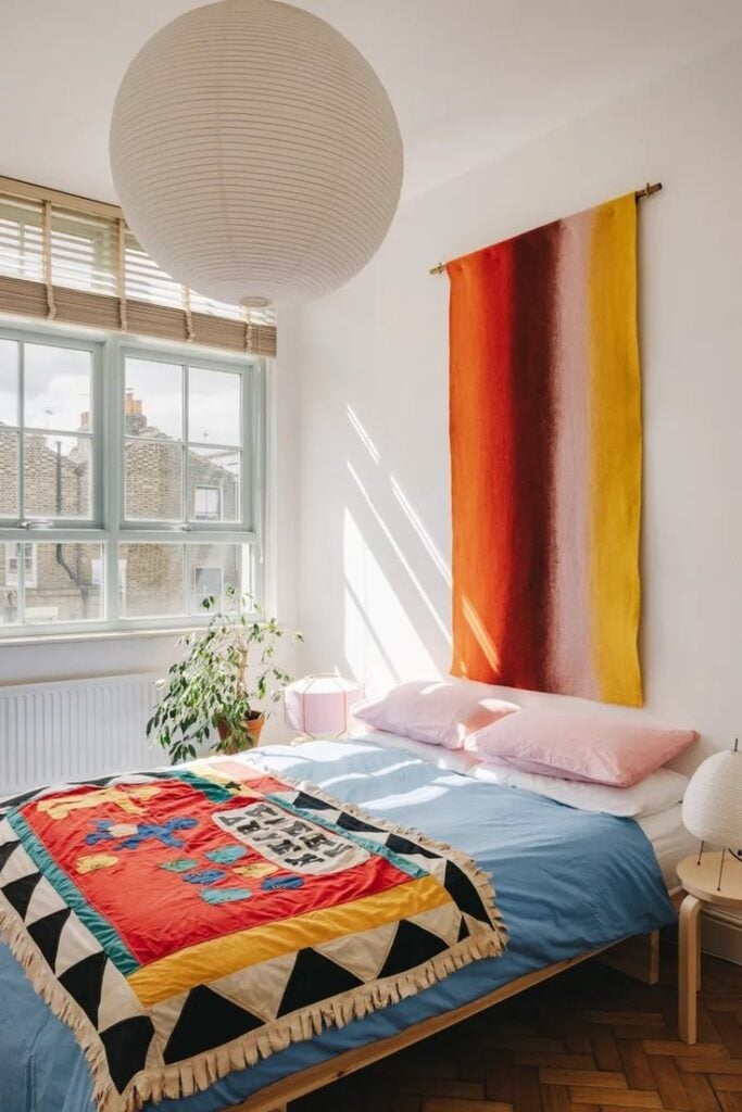 Quarto com cama sem cabeceira com tecido na parede