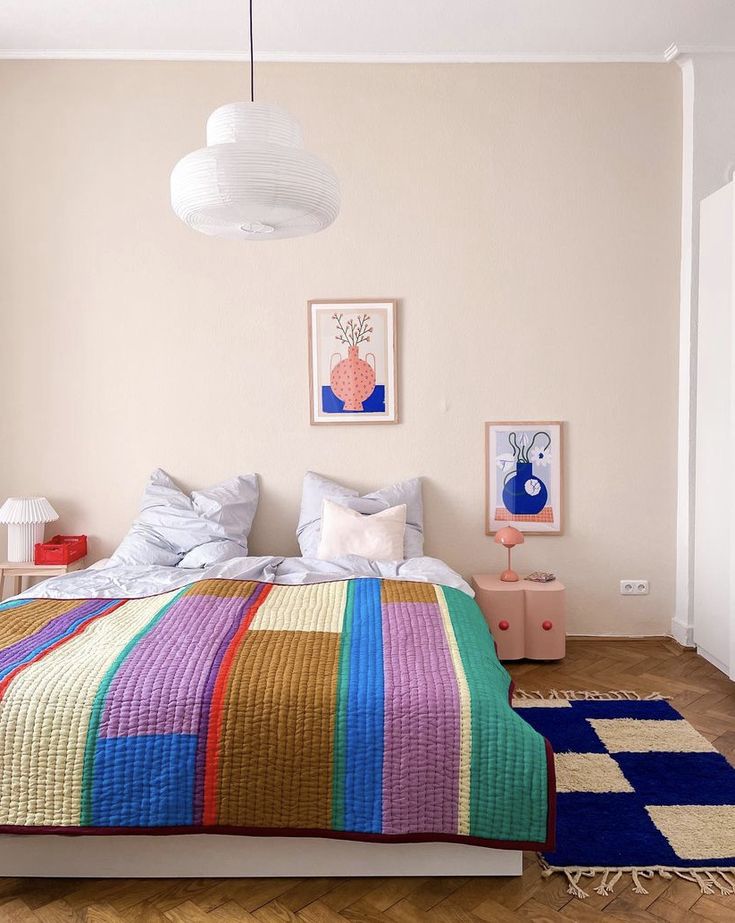Quarto colorido e criativo com cama sem cabeceira e com quadros na parede