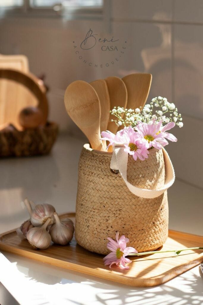 Cesto de palha com alça, flores e colheres de pau