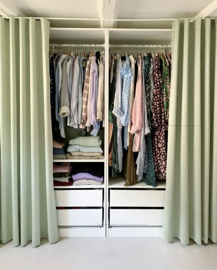 Closet com prateleiras, gavetas e cortina verde