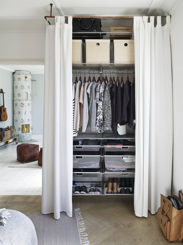 Closet com prateleiras, cabideiro e cortina branca
