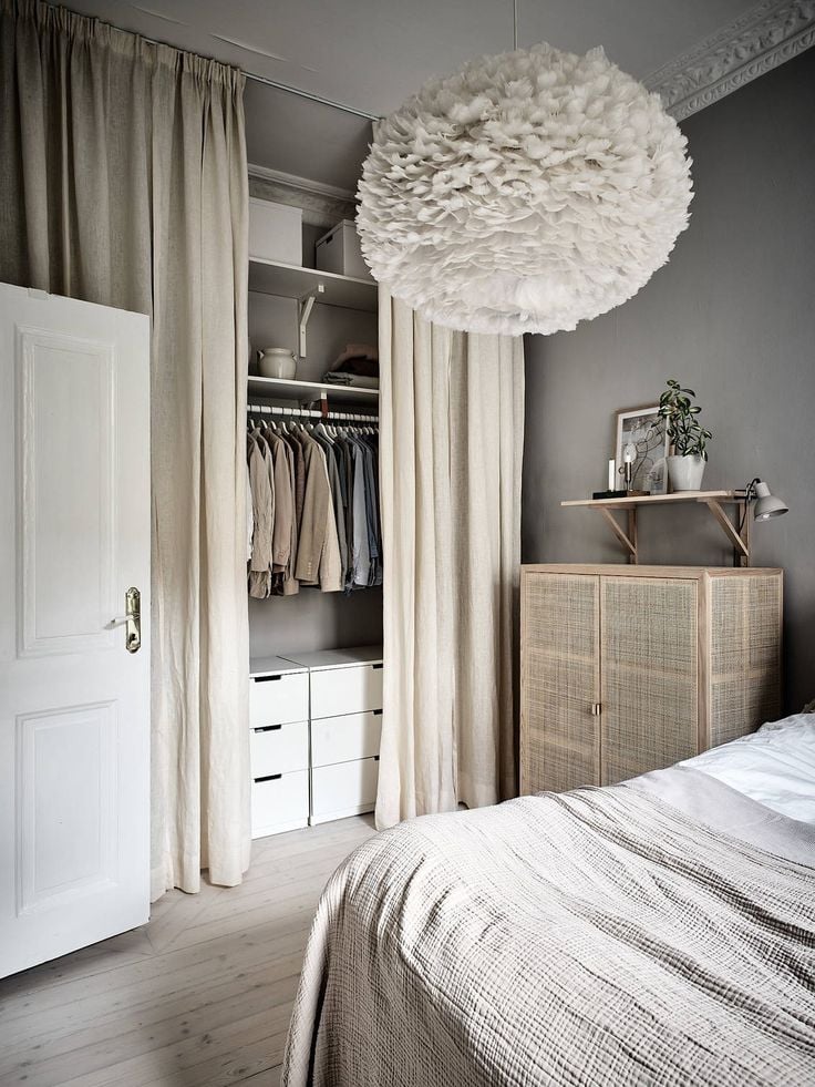 Closet pequeno com cortinas e gavetas