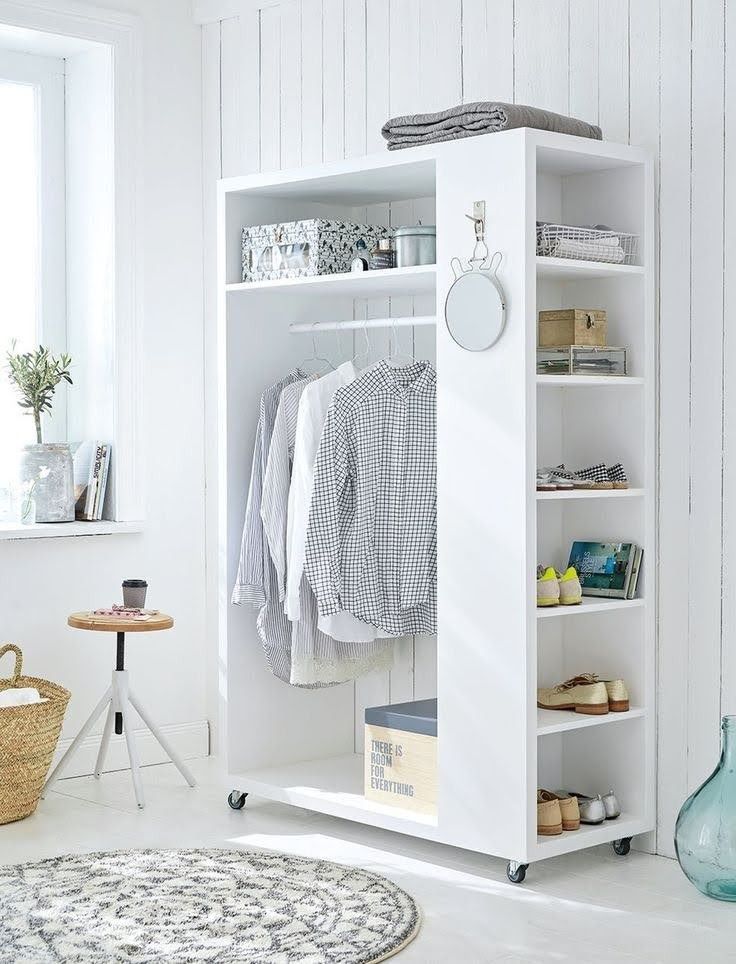 Closet branco com espaço para cabides e nichos