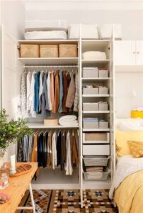 Closet pequeno com cabideiro, prateleiras e caixas