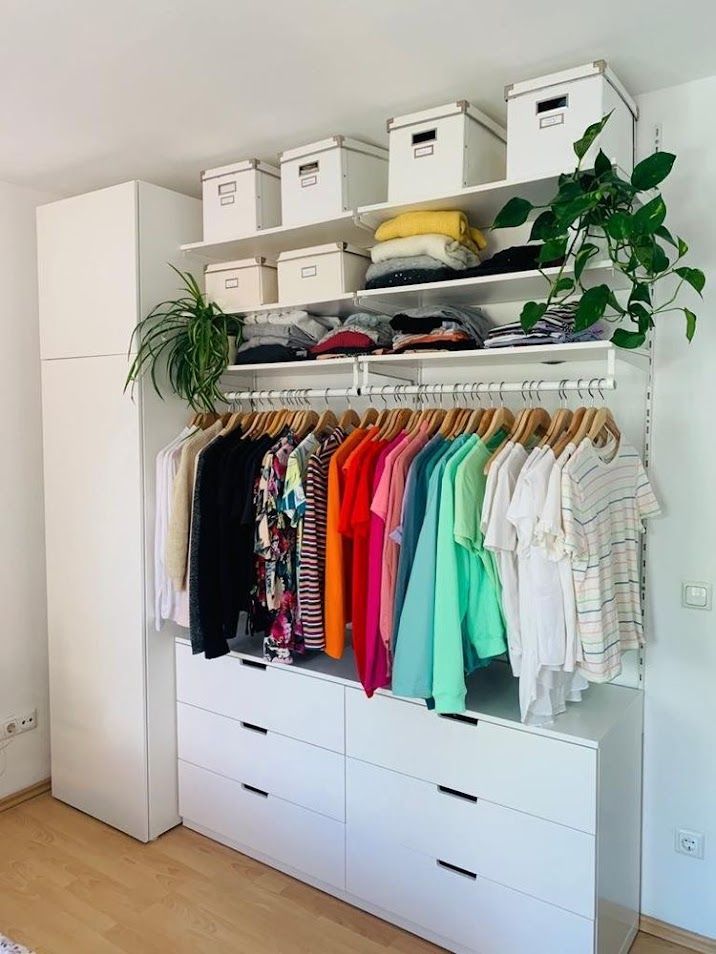 Closet branco com gavetas, caixas organizadoras e cabideiros